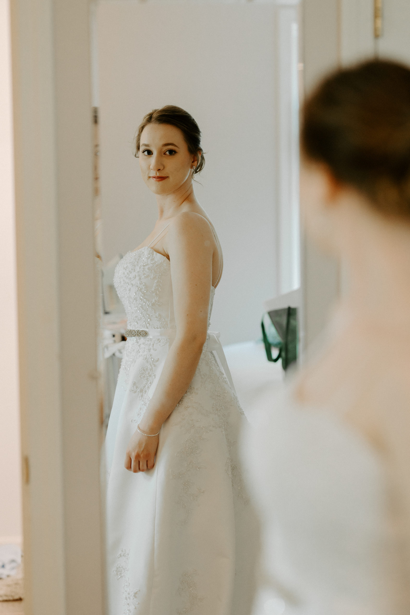 bride getting ready and looking at self in mirror