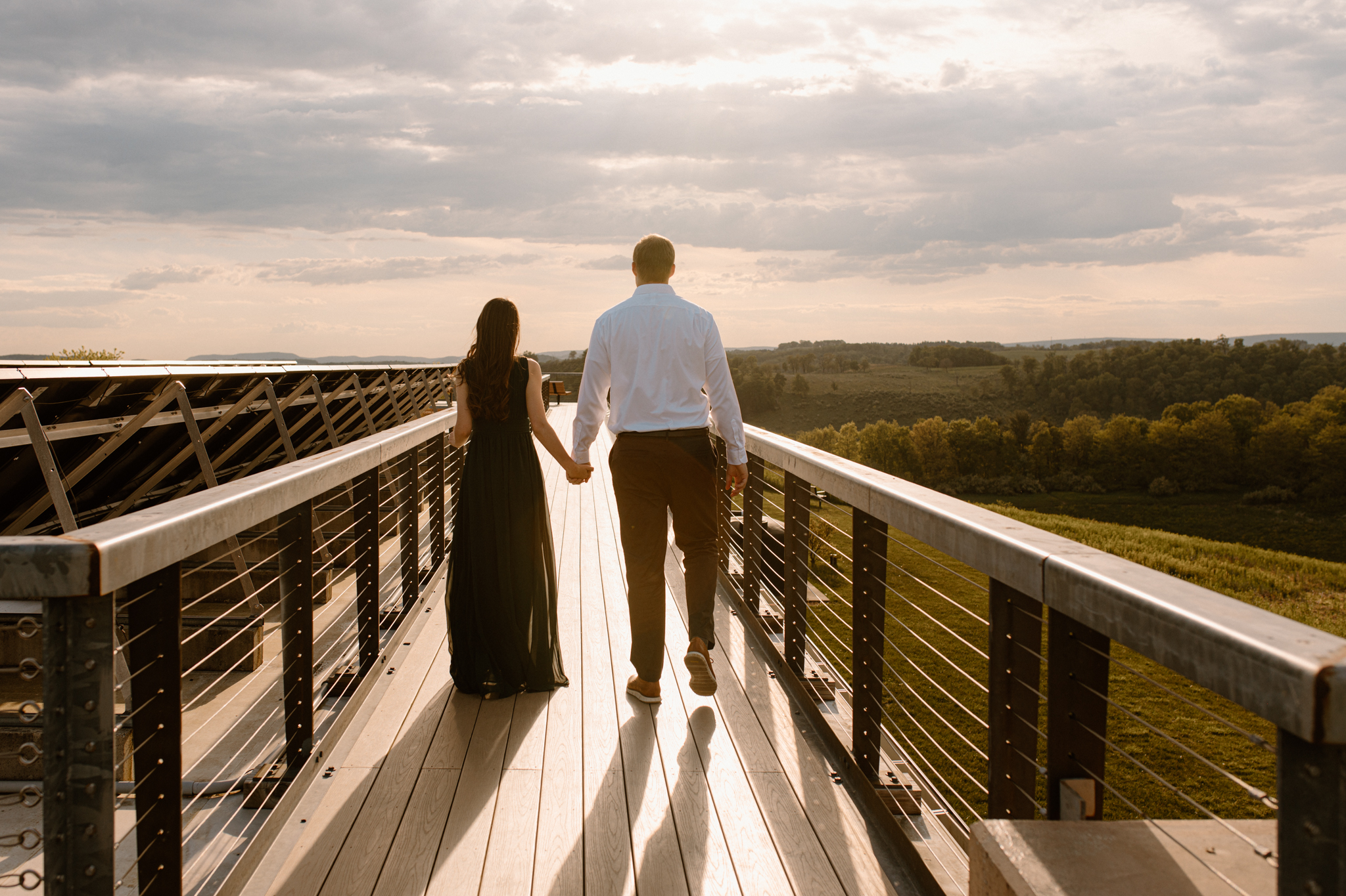 couple walking on overlook towards sunset