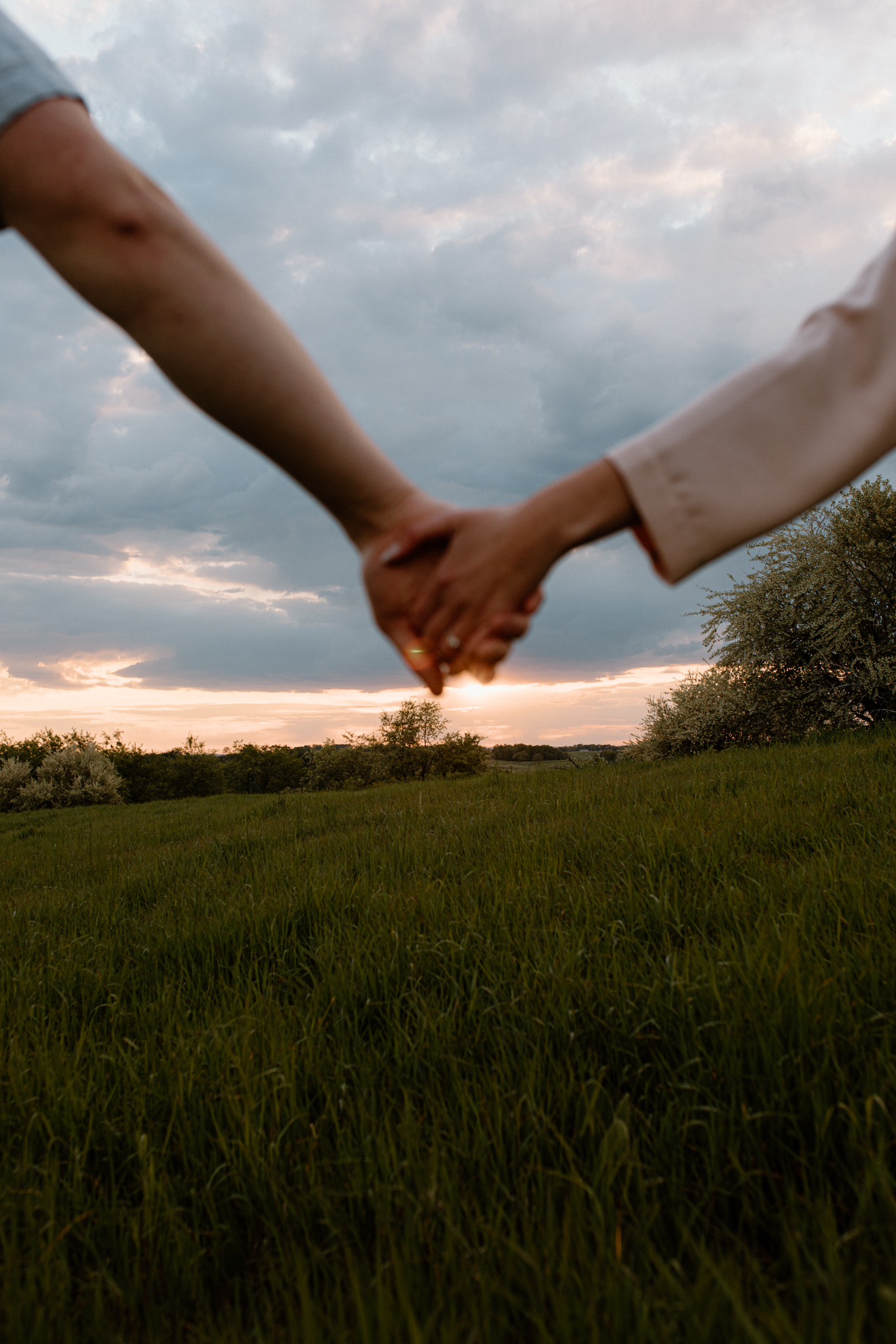 holding hands blurred with sunset in the focus