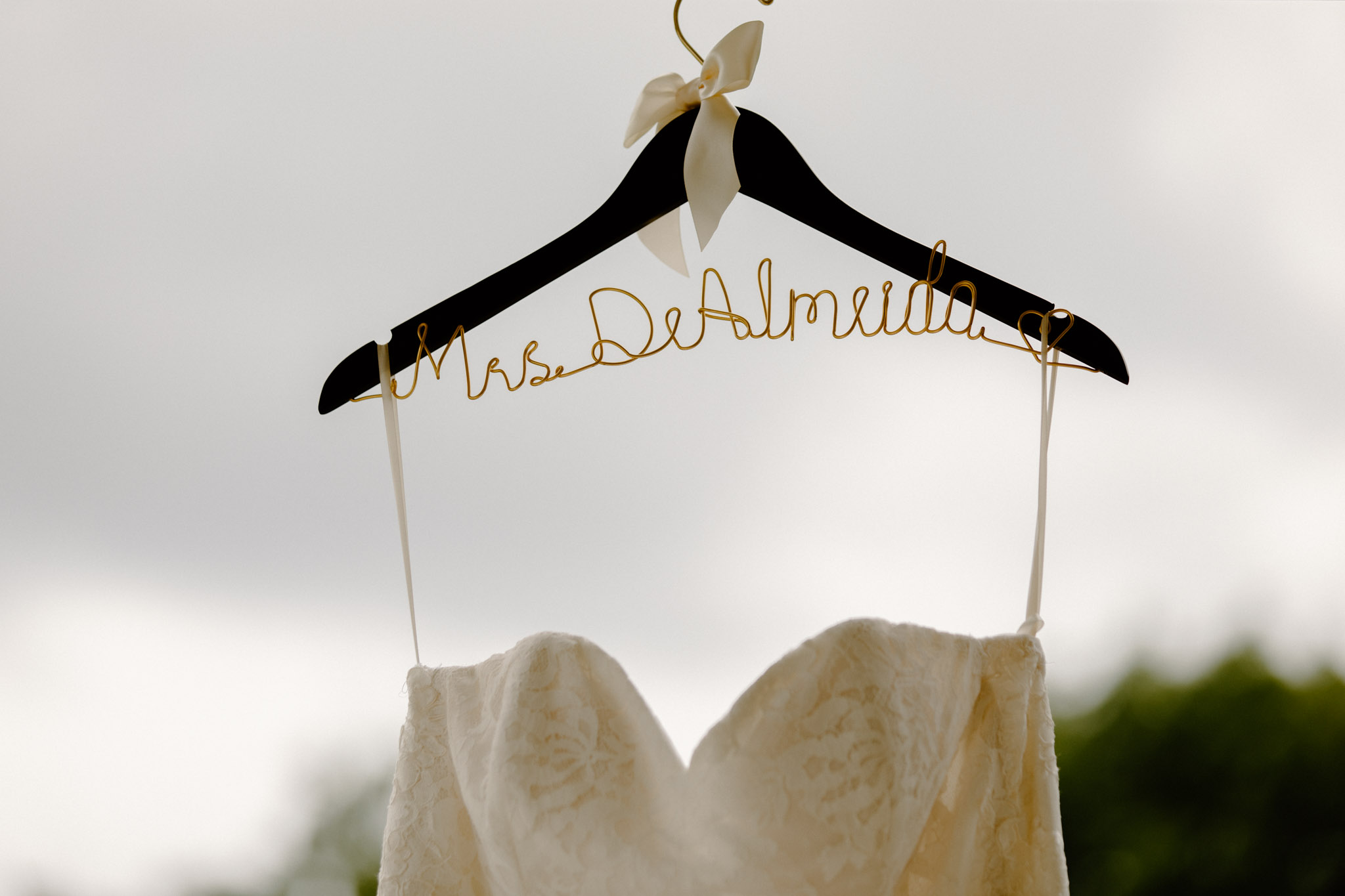 wedding dress hanging up with last name on hanger