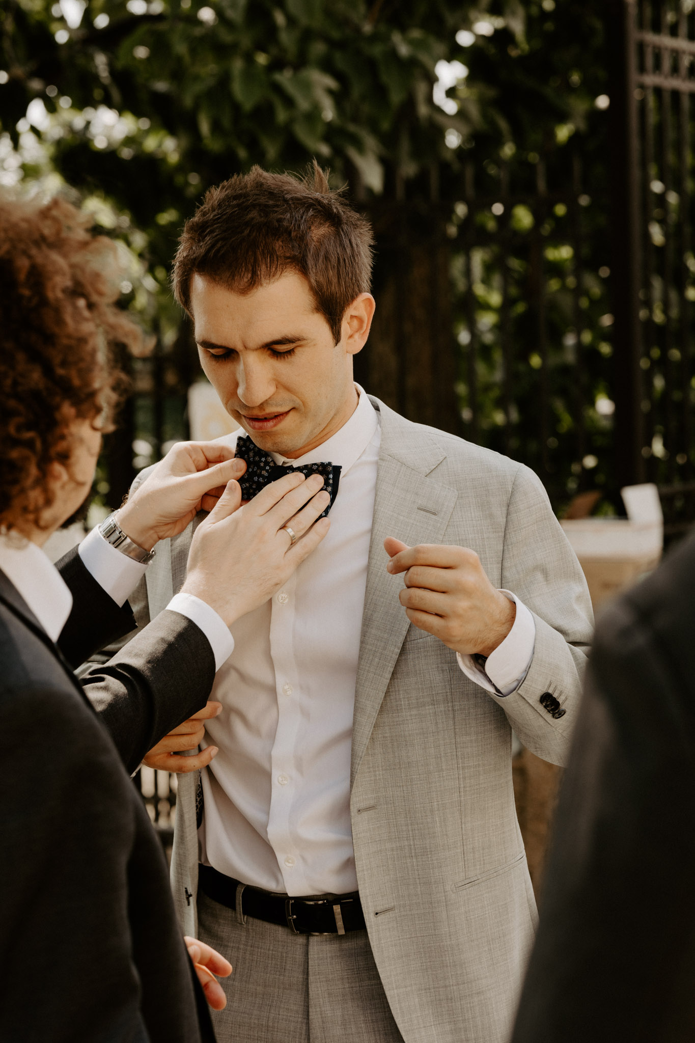 groomsmen adjusting grooms tie